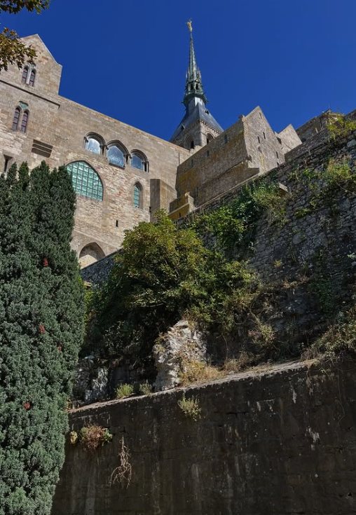 The Gothic windows of La Merveille and the abbey spire from the foot of the ramparts