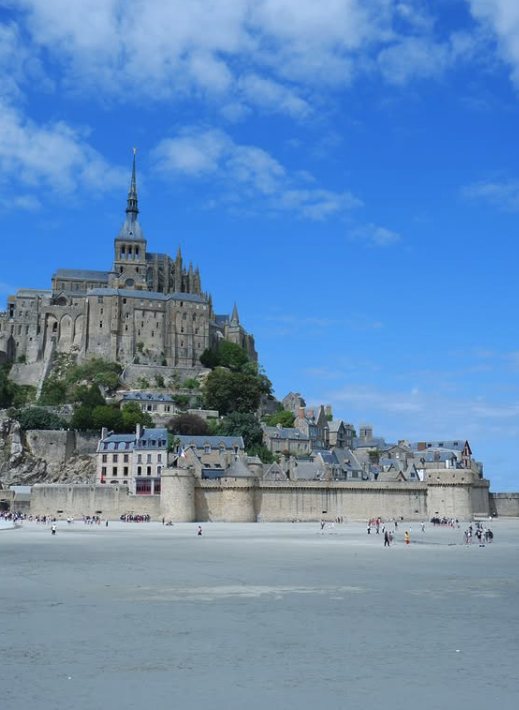 The ramparts and the abbey of Mont Saint-Michel from the wet sand at low water